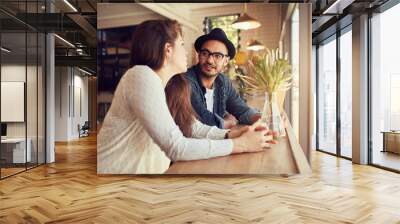 Young couple relaxing in a coffee shop. Wall mural