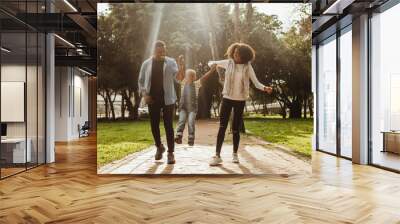 Young family having fun together at park Wall mural