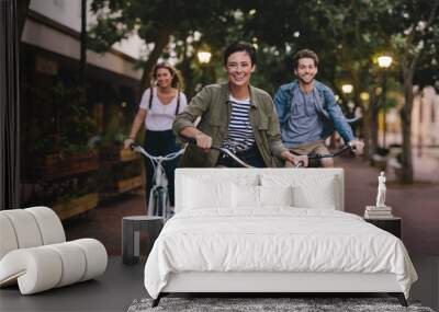 Young friends cycling in the city Wall mural