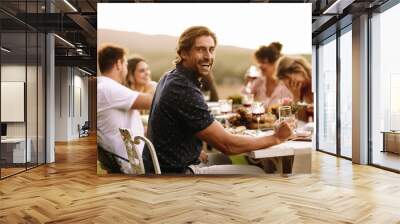 Young guy enjoying at outdoor party with friends Wall mural