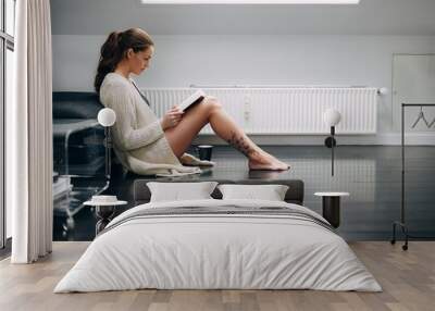 Young lady reading a book at home Wall mural