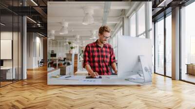 young man working in modern workplace Wall mural