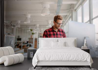 Young man working on computer in modern office Wall mural