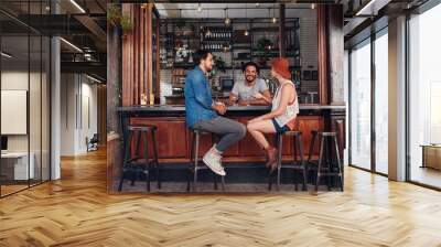 young people sitting in a cafe and talking Wall mural