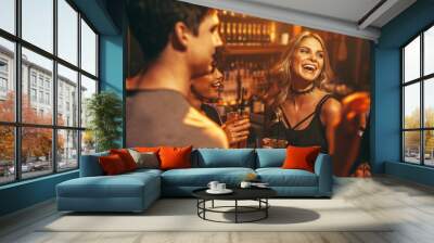 Young woman having drink at nightclub with friends Wall mural