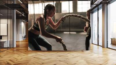 young woman working out with battle ropes Wall mural