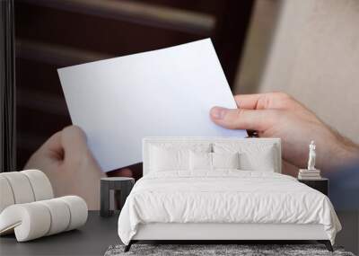 Male hands holding a letter, close up, focus on letter. Envelope with a copy-space. Wall mural