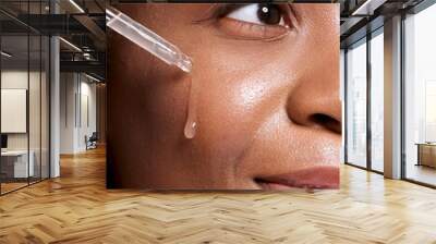 Black woman, dropper and facial skincare cosmetics for beauty, hydration or oil treatment for healthy face. Closeup of African American female applying serum to cheek for skin hydrate, glow or shine Wall mural