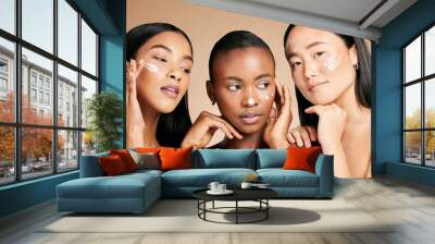 Face cream, skincare and women in studio for wellness, grooming and hygiene against brown background. Friends, beauty and lotion for girl group with different, facial and skin product while isolated Wall mural