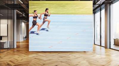 Sports, sprint runner women in competition on stadium with lens flare for power, speed and motivation. Professional athlete fitness people marathon running, training for goals, challenge and energy Wall mural