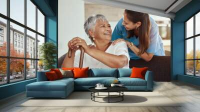 Happy, relax and senior woman with caregiver smile while sitting on a living room sofa in a nursing home. Support, help and professional nurse or healthcare worker helping elderly lady or patient Wall mural