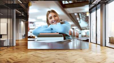 Portrait, woman and student in library, studying and higher education for knowledge, growth or learning. University, female academic or lady with books, smile or relax with scholarship or information Wall mural