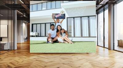 Property, happy family and sold sign with smile, relax and excited people rest, sit and bond on grass. Real estate, house sale and family moving into new home together, joy and carefree relocating Wall mural