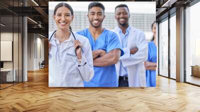 Were here to take care of you. Shot of a group of doctors standing against a city background. Wall mural