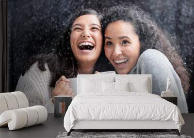 Women, friends and snowfall with coffee, laugh and happiness together on holiday with warm drink. Snow, girl or woman in winter with laughing, love and happy with matcha, espresso or latte outdoor Wall mural