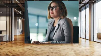 Desktop, typing and business woman in office, working late on project and focus at night. Computer, professional and female person writing email, report or planning, reading and overtime for deadline Wall mural