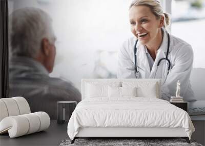 Im glad to see youre in such great health. Cropped shot of a mature female doctor working with a senior male patient in her office in the hospital. Wall mural