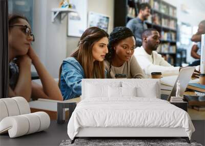 Laptop, library and university girl students studying together for education in preparation of a test or exam. Computer, college and scholarship with female friends searching for information online Wall mural