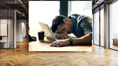 Defeated by the deadline. Shot of an exhausted young businessman sleeping at his desk during a late night at work. Wall mural