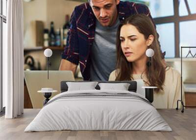 Planning their monthly budget together. Cropped shot of a young couple using a laptop while going through paperwork together at home. Wall mural