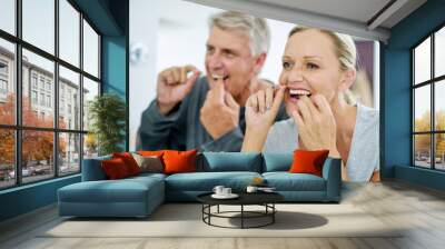 Senior, couple and floss their teeth for fresh breath and a smile and healthcare at home. Elderly woman and man cleaning mouth for dental care in the bathroom for a healthy lifestyle and insurance. Wall mural