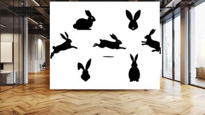 Set of Rabbit silhouettes. Easter bunnies. Isolated on a white backdrop. A simple black icons of hares. Cute animals. Suitable for logo, emblem, pictogram, print, design element for greeting card Wall mural