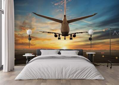 Airplane landing to airport runway in sunset light Wall mural