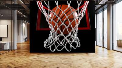 Basketball going through the basket on black backgorund Wall mural