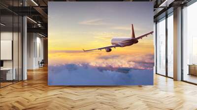 Commercial airplane flying above clouds Wall mural