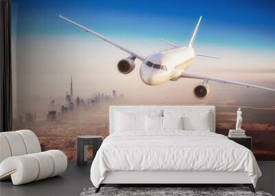 Commercial airplane flying over modern city Wall mural