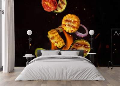 Flying pieces of vegetable from grill grid, isolated on black background Wall mural