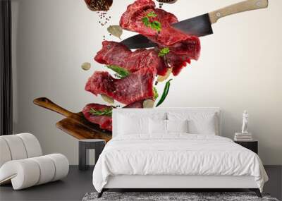 Flying raw steaks with ingredients, food preparation concept Wall mural