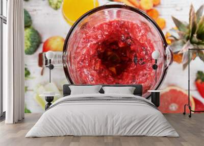 Mixing pieces of fruits in blender, top view. Wall mural