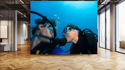 Scuba divers kissing each other underwater Wall mural