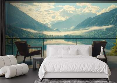 Two chairs and a table are on a patio by a lake and mountains Wall mural