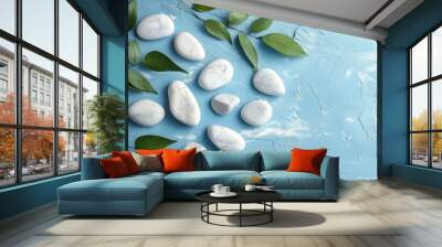 White rocks and green leaves create a scene on a blue background Wall mural