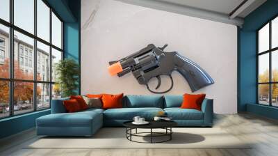 Closeup shot of a black toy gun on the table Wall mural