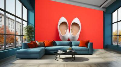 White high heeled shoes on red background - top view concept - heels pointing up Wall mural