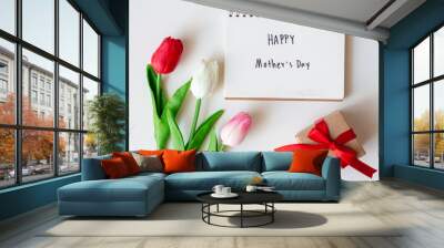 Write text happy mother's day on paper notebook with tulips flowers on white background. Wall mural