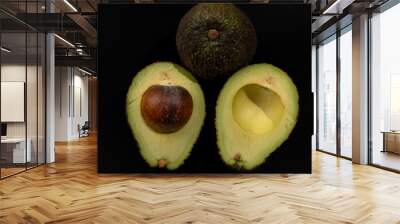 A close up of an avocado with the seed removed. The avocado is cut in half and the seed is visible Wall mural