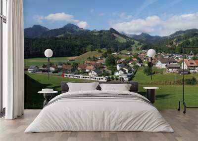 Alpine panorama with houses and modern train at european Gruyeres town in Switzerland on August Wall mural