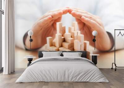 Safety business development concept. Wooden blocks covered by hands.  Wall mural