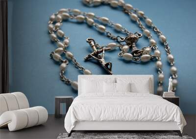 silver necklace rosary on blue background Wall mural