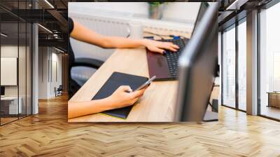 Young businesswoman using her touchpad and laptop. She is sittin Wall mural