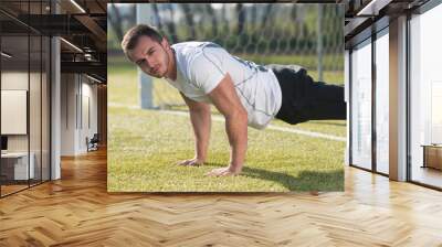 Young Man Doing Push-up Exercise in the Gym Wall mural