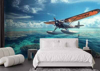 Seaplane flying over turquoise water and coral reefs. Wall mural