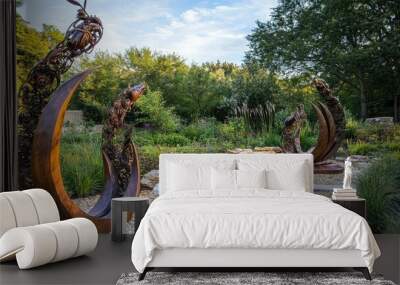 Two wooden sculptures in a garden setting. Wall mural