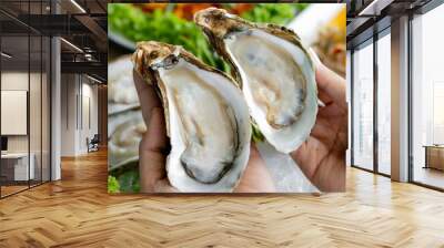 Oysters with lemon in a green plate on a wooden table background. Wall mural