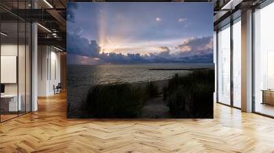 Pylons and coastline along the Eastern Shore of Virginia at sunset with a storm brewing in the background Wall mural