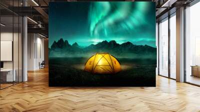 A glowing yellow camping tent under a beautiful green northern lights aurora. Travel adventure landscape background. Photo composite. Wall mural